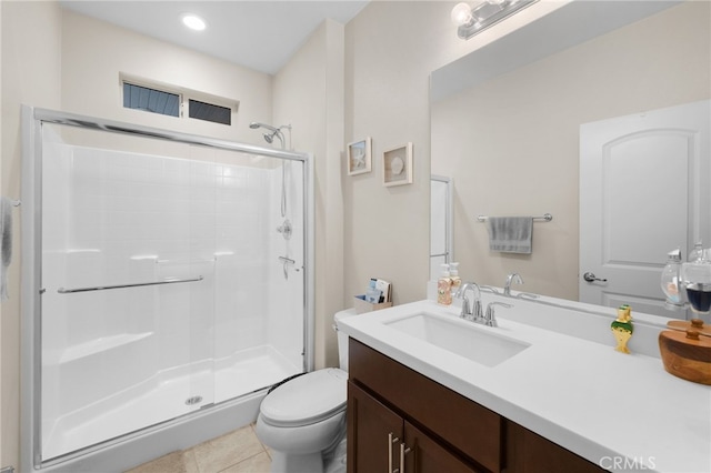 bathroom featuring tile patterned flooring, toilet, vanity, and walk in shower