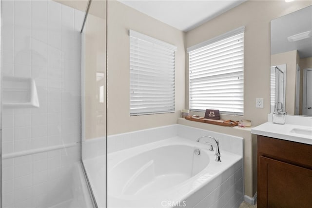 bathroom with vanity and shower with separate bathtub