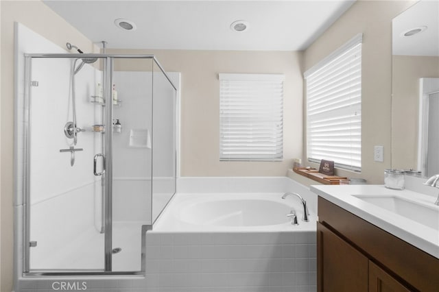 bathroom with vanity and shower with separate bathtub