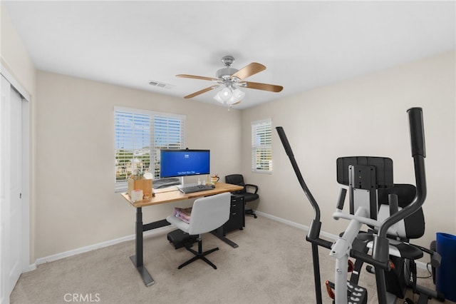 carpeted office space featuring ceiling fan