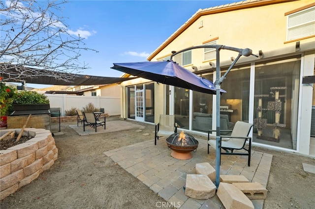 back of property featuring a patio area and a fire pit