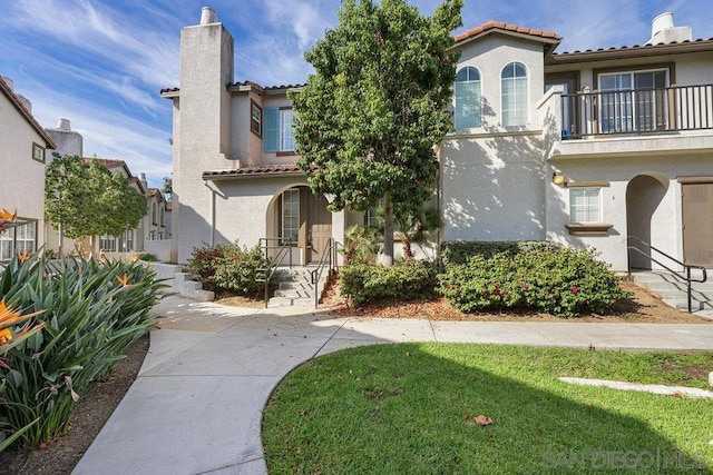 mediterranean / spanish home with a front lawn