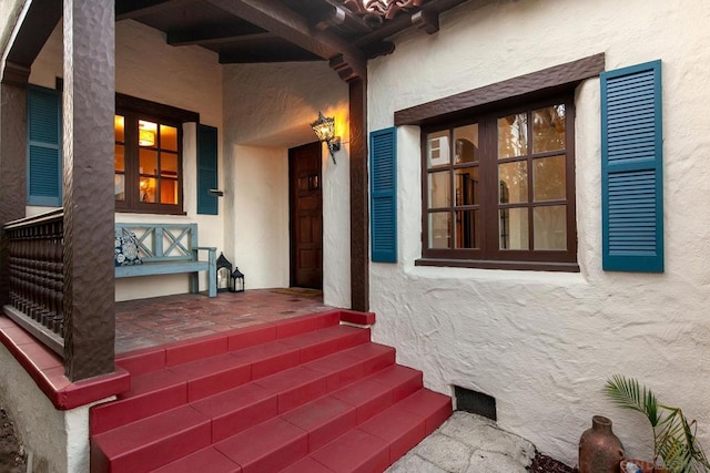 view of exterior entry featuring a porch and french doors