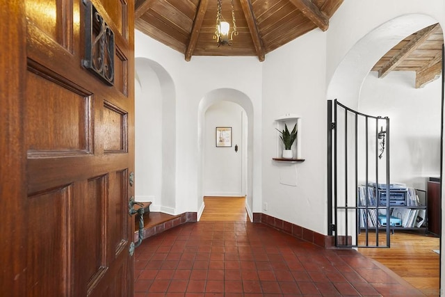 tiled entrance foyer featuring lofted ceiling with beams and wood ceiling