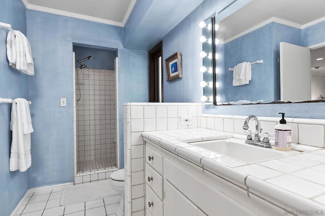 bathroom with crown molding, tile patterned flooring, a tile shower, vanity, and toilet