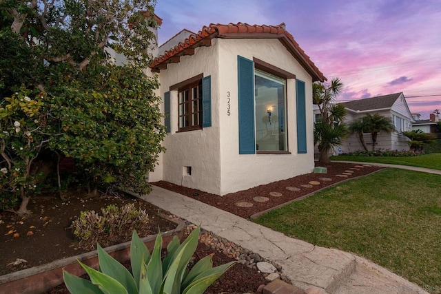 property exterior at dusk with a yard