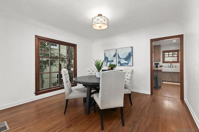 dining space featuring dark wood-type flooring and sink