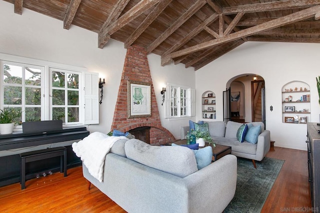 living room featuring beamed ceiling, high vaulted ceiling, wooden ceiling, hardwood / wood-style flooring, and a fireplace