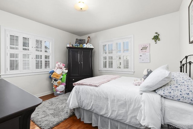 bedroom with multiple windows and wood-type flooring