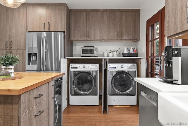 laundry area featuring hardwood / wood-style flooring, washer and dryer, and wine cooler