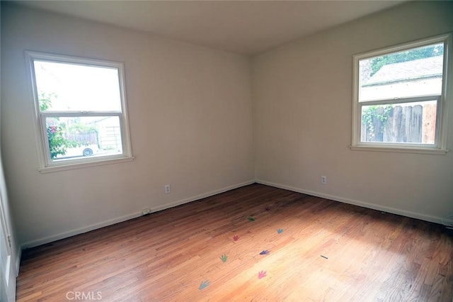 spare room featuring plenty of natural light and hardwood / wood-style floors