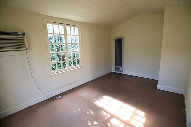 empty room with lofted ceiling, a wall unit AC, and plenty of natural light