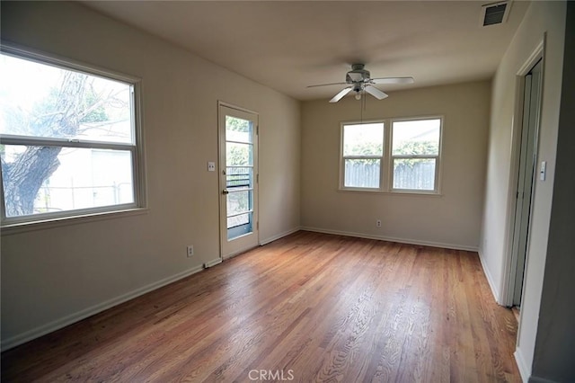 spare room featuring ceiling fan, a healthy amount of sunlight, and light hardwood / wood-style floors