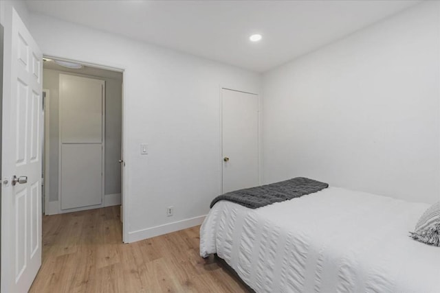 bedroom with light hardwood / wood-style floors and a closet