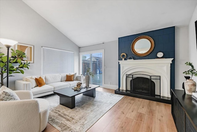 living room featuring high vaulted ceiling and light hardwood / wood-style flooring