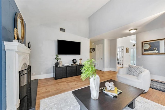 living room featuring wood-type flooring and high vaulted ceiling