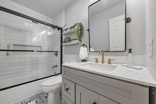 full bathroom with vanity, toilet, and combined bath / shower with glass door