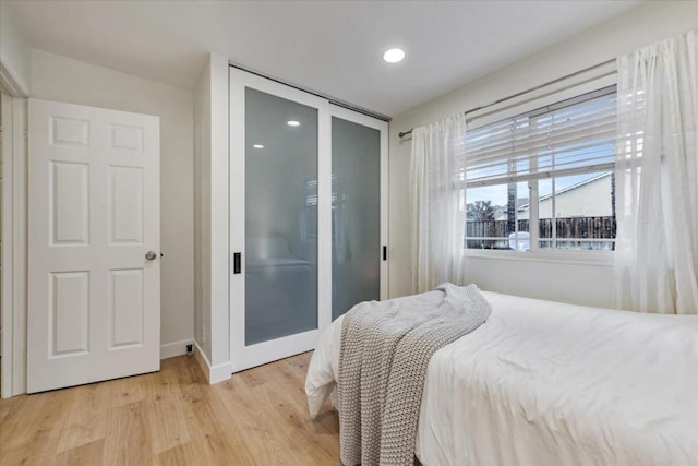 bedroom with light hardwood / wood-style flooring and a closet