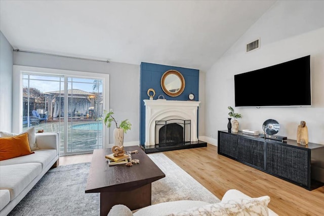 living room with hardwood / wood-style flooring and vaulted ceiling