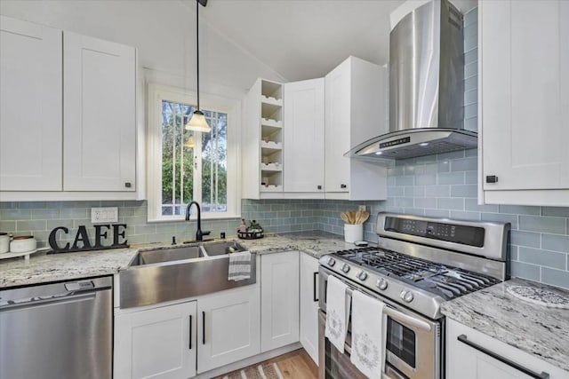 kitchen featuring wall chimney range hood, stainless steel appliances, sink, and white cabinets