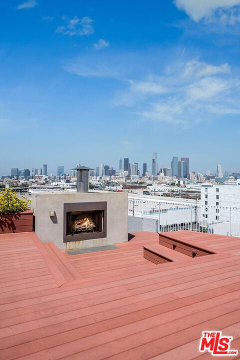 wooden deck with an outdoor fireplace