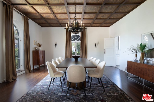 dining room with dark hardwood / wood-style floors, coffered ceiling, and a notable chandelier