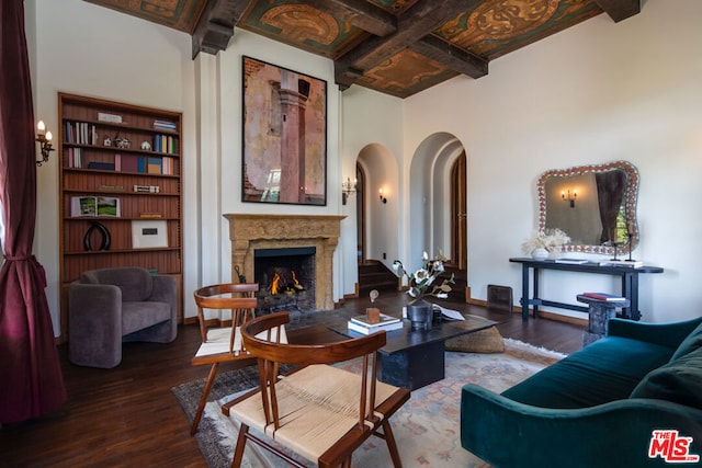 living room with coffered ceiling, hardwood / wood-style floors, beamed ceiling, and a high ceiling