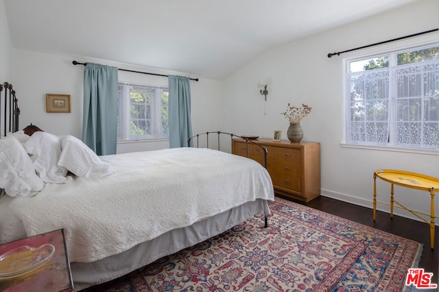 bedroom with vaulted ceiling and dark wood-type flooring