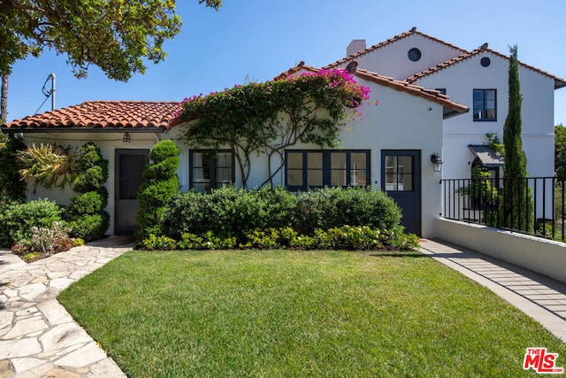 mediterranean / spanish-style house featuring a front yard