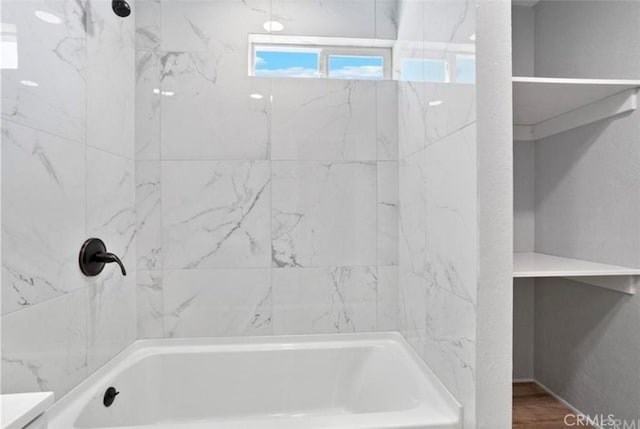 bathroom featuring tiled shower / bath combo and hardwood / wood-style floors