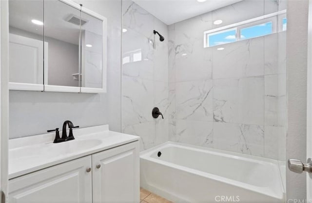 bathroom with vanity and tiled shower / bath combo