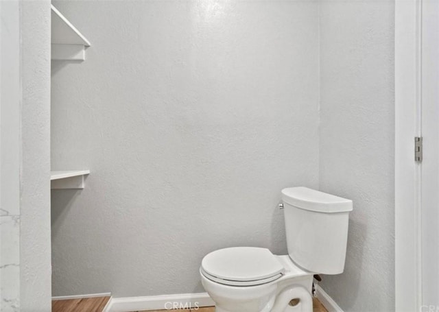 bathroom featuring hardwood / wood-style flooring and toilet