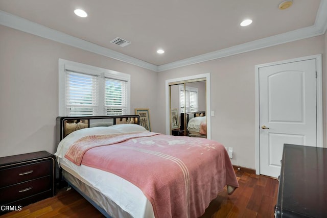 bedroom featuring crown molding, dark hardwood / wood-style floors, and a closet