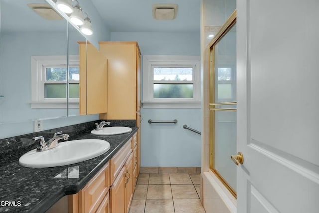 bathroom featuring vanity, combined bath / shower with glass door, and tile patterned flooring