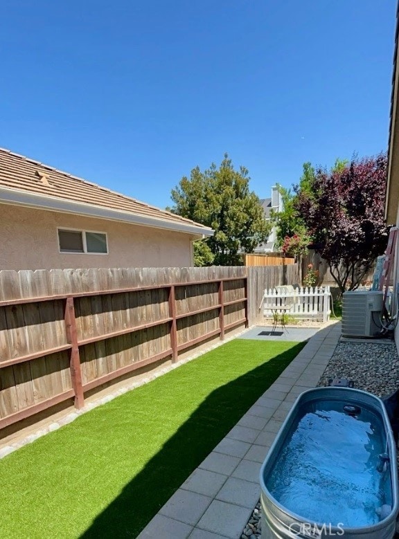 view of yard with central AC and a patio area