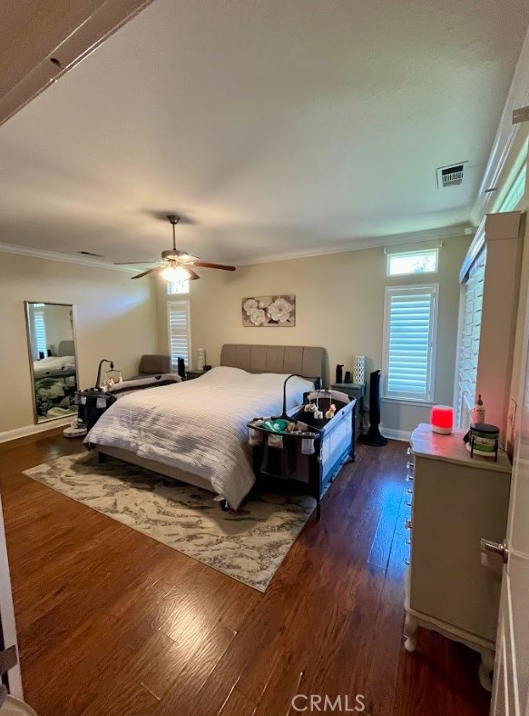 bedroom featuring ornamental molding, dark hardwood / wood-style floors, and ceiling fan