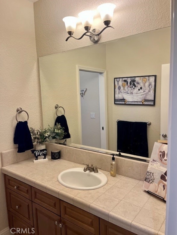 bathroom featuring vanity and a notable chandelier