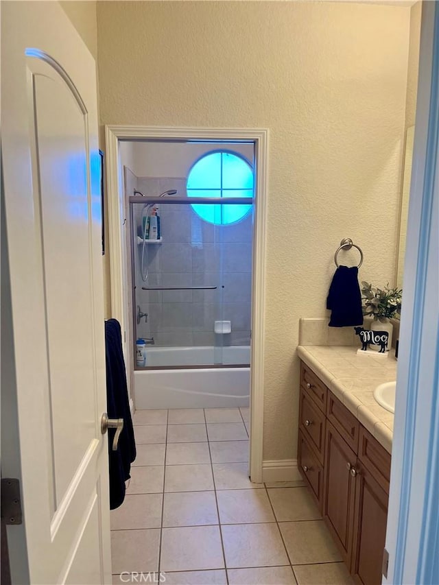 bathroom with tile patterned flooring, vanity, and combined bath / shower with glass door