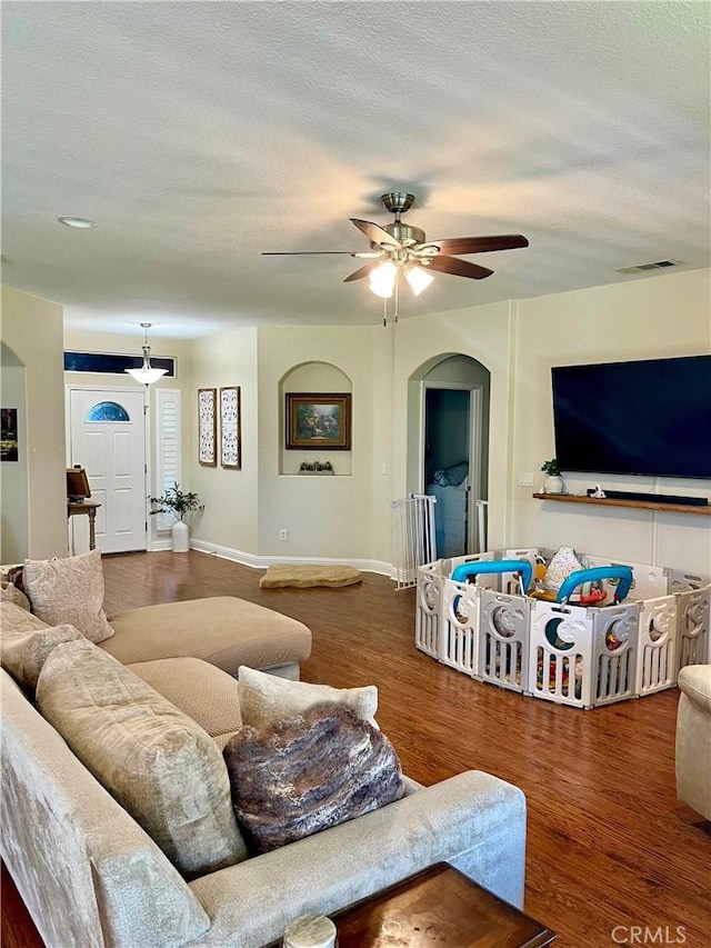 living room featuring hardwood / wood-style floors, a textured ceiling, and ceiling fan