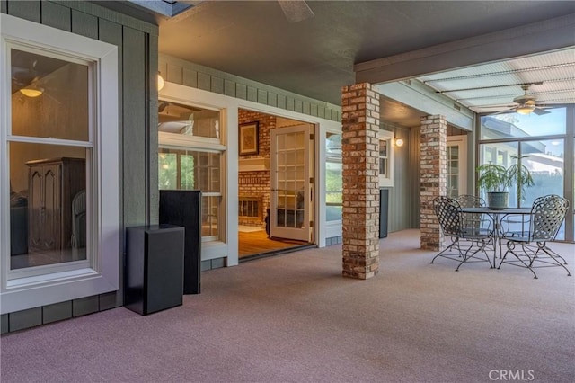 unfurnished sunroom with beam ceiling, ceiling fan, and ornate columns