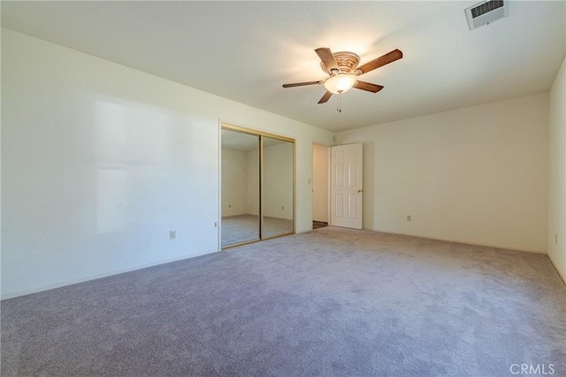 unfurnished bedroom featuring visible vents, ceiling fan, a closet, and carpet floors