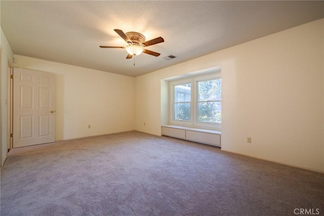 unfurnished room with ceiling fan and carpet flooring