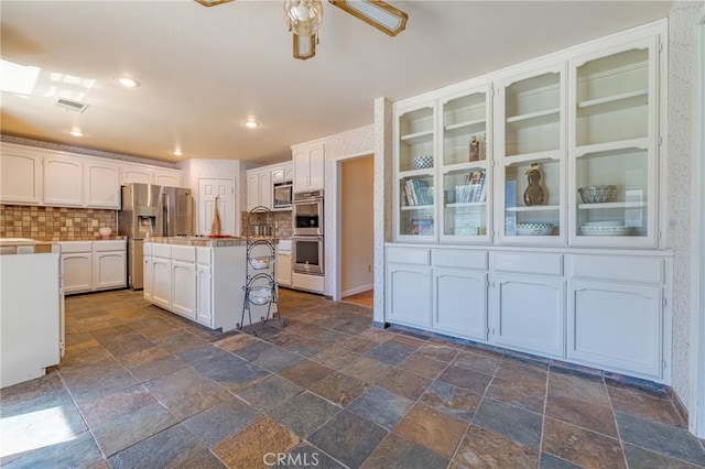kitchen with ceiling fan, white cabinetry, visible vents, and stainless steel appliances