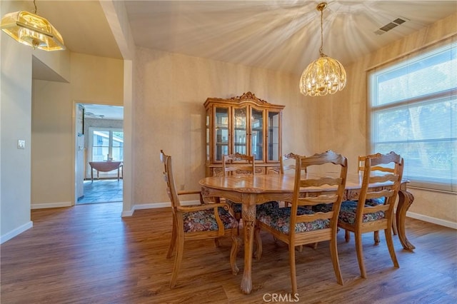 dining room with plenty of natural light, a chandelier, and wood-type flooring