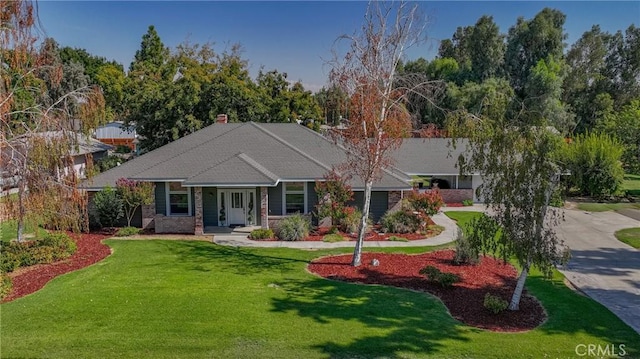ranch-style home featuring concrete driveway and a front yard