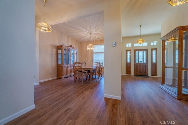entryway with baseboards, a chandelier, and wood finished floors