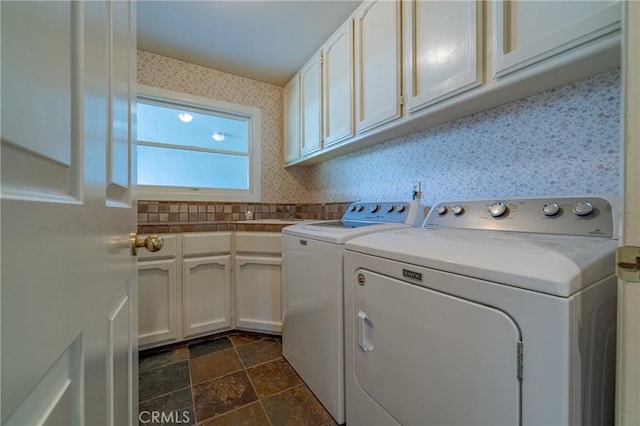 washroom featuring cabinet space, stone finish flooring, independent washer and dryer, and wallpapered walls