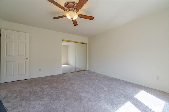 unfurnished bedroom with ceiling fan, carpet floors, and a closet