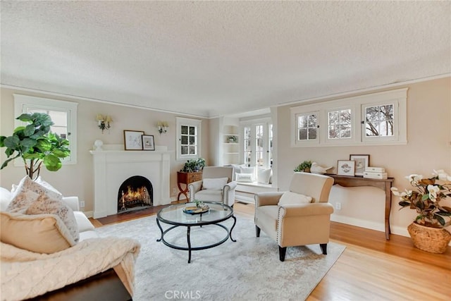 living room featuring light wood-type flooring and a textured ceiling