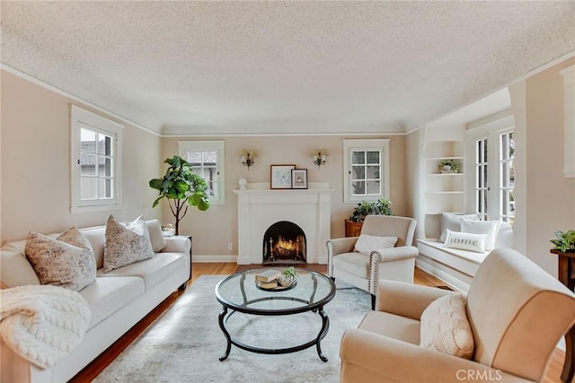 living room featuring crown molding, wood-type flooring, and a textured ceiling